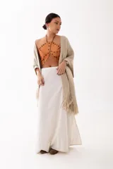 Ruana de tejido de punto en color beige, con diseño abierto y terminaciones con flecos en los bordes.