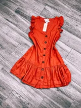 Vestido corto color terracota con escote en V, mangas cortas con volados, abotonado al frente y falda con volados.