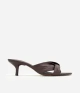 Sandalia mule Satinato de cuero marrón oscuro, con detalle de nudo frontal, taco kitten fino y puntera abierta.