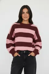Sweater de punto grueso con diseño de rayas horizontales anchas en tonos bordó y rosado, de corte holgado, manga larga y cuello redondo a la base.