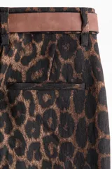 Pantalón amplio de tiro alto confeccionado en mezcla de viscosa, con estampado animal print de leopardo, pinzas delanteras y traseras, y diseño de pernera ancha. Incluye un cinturón delgado de cuero marrón con hebilla metálica.