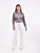 Camisa color beige de manga larga con cuello clásico y cierre frontal con botones.