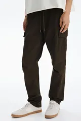 Pantalón cargo slim fit marrón, con cintura elástica ajustable mediante cordón, bolsillos laterales con solapa y costuras decorativas en las rodillas.