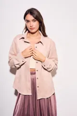 Camisa color marrón de gamuza sintética, de corte recto, con cuello clásico, cierre frontal con botones y mangas largas.