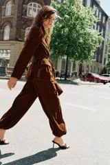 Pantalón de tiro medio confeccionado en terciopelo color marrón, con diseño bombacho, bolsillos delanteros y bajos con puño elástico. Cuenta con cierre lateral oculto.