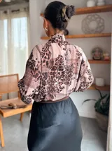 Camisa de manga larga con estampado animal print y detalles de encaje en el frente. Presenta un cuello con lazo integrado y un diseño fluido y elegante.