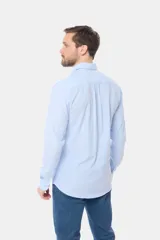 Camisa celeste de lino de manga larga con bolsillo en el pecho y botones personalizados.