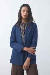 Blazer de jean color celeste con silueta recta y corte sastrero. Presenta solapas clásicas, cierre frontal con botón forrado, bolsillos con tapa y detalle de botones forrados en los puños.