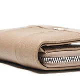 Billetera de tamaño compacto en símil cuero color taupe, con textura granulada y cierre perimetral. Presenta un diseño con costuras verticales decorativas y el logo de la marca en metal plateado en la parte frontal.