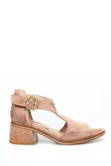 Sandalia de gamuza color beige, con diseño de pulsera al tobillo, hebilla metálica dorada y taco cuadrado de madera.