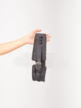 Faja elastizada agamuzada color negro, con apliques de tachas plateadas y hebillas metálicas plateadas.