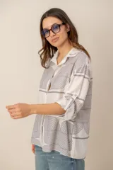 Camisa de manga larga de corte holgado, color blanco con estampado abstracto y floral en tonos ocre y azul.