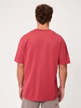 Remera negra de corte suelto y mangas cortas, con pequeño bordado a tono en el pecho.