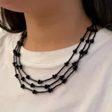 Collar triple de color negro, confeccionado artesanalmente con canutillos largos, cuentas de vidrio y cristal checo.