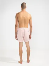 Short de baño para hombre con estampado de rayas verticales celestes y blancas. Cuenta con cintura elástica con cordón ajustable, bolsillos laterales y un bolsillo trasero. Confeccionado en tejido liviano de secado rápido.