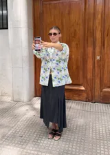 Camisa de lino con cuello clásico y mangas abullonadas, con estampado floral en tonos blanco, verde y azul.
