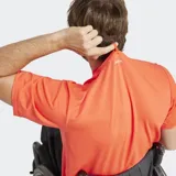 Remera de entrenamiento Adidas, color naranja vibrante, con cuello redondo y logo de las 3 barras en blanco en el pecho. Presenta un corte clásico y espalda de malla para mayor ventilación.