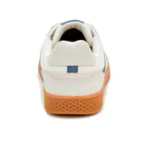 Championes Caterpillar modelo Pause Retro, de diseño minimalista con estética vintage. Presentan una combinación de lona blanca y detalles en gamuza en tonos claros, con una banda lateral azul que incluye el logo de la marca. Se destacan por su suela de goma color caramelo con textura de panal y logo grabado en el lateral.