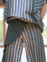 Pantalón de lino y algodón a rayas verticales en tonos celeste y blanco, con corte palazzo y volados en el lateral.