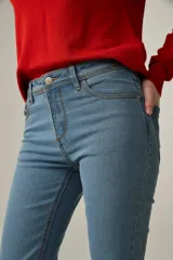 Pantalón de jean azul de corte skinny y tiro medio, con bolsillos delanteros y traseros.