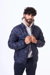 Campera puffer negra con diseño termosellado, cuello alto y cierre frontal completo. Confeccionada en nylon, ofrece ligereza y protección.