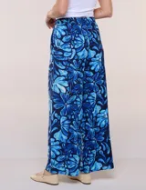 Pantalón de poliéster de corte ancho tipo palazzo y calce relajado, con estampado de hojas en tonos azules, cintura alta elastizada con cordón ajustable y bolsillos laterales.