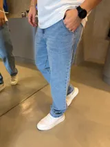Jean de corte baggy en color azul claro, con diseño de pierna recta y holgada. Cuenta con bolsillos laterales y cierre frontal.