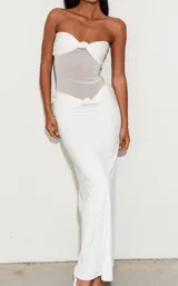 Vestido largo blanco de corte sirena con diseño strapless, cuerpo drapeado con nudo central y sección semitransparente en el torso.