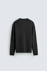 Jersey relaxed fit de punto acanalado color marrón oscuro, con cuello redondo tipo panadera y cierre frontal de tres botones. Tiene manga larga y efecto lavado.