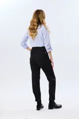 Pantalón de gabardina marrón, de corte recto con pinza en el bajo y detalles de botones en los tobillos.