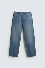 Pantalón de jean con corte recto desde la cadera hasta el tobillo, de tiro medio y ajuste holgado. Presenta diseño de cinco bolsillos, cierre frontal con cremallera y botón, y acabado con efecto lavado.