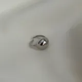 Anillo plateado con forma de esfera.