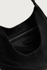 Bolso de hombro tipo shopper en color negro, con diseño liso y cierre magnético. Cuenta con un bolsillo interior con cremallera y asa ajustable.