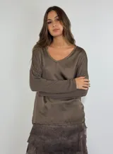 Blusa color beige con escote en V y mangas largas abullonadas.