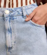 Bermuda regular de jeans celeste con cintura alta, bolsillos delanteros y traseros, cierre con botón y cremallera.
