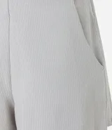 Bermuda deportiva color gris claro, confeccionada en microfibra acanalada, de corte holgado y largo a medio muslo.