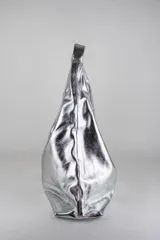 Cartera de cuero vacuno con pelo en diseño animal print similar a piel de ciervo, silueta triangular y asa integrada.