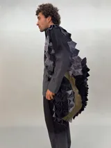 Bolso de gran tamaño confeccionado artesanalmente con técnica de ensamblado de cuadrados de lana merino afiltrada en tonos violeta y gris. Presenta un diseño texturizado y voluminoso, con forro interior de algodón y bolsillo con cierre.
