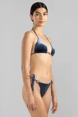 Top de bikini triángulo azul con textura a rayas finas y charm metálico color oro rosado en el centro del escote.