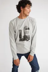 Remera de manga larga color gris melange, con cuello redondo y estampado gráfico en blanco y negro de la ciudad de Nueva York en el frente.