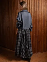 Pollera larga de corte amplio y voluminoso, con estampado de cuadros escoceses en tonos azul marino y amarillo. Presenta cintura elástica y bolsillos laterales.