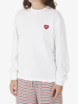 Remera de manga larga Carhartt WIP de corte holgado, color negro, con cuello redondo y un pequeño aplique bordado en forma de corazón rojo con el logo de la marca en el pecho.