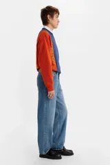 Jeans de corte holgado y tiro medio, confeccionados en denim de algodón con un ligero toque de elastano. Presentan un lavado medio clásico, diseño de cinco bolsillos y cierre frontal con botón y cremallera.