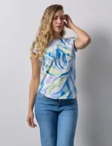 Remera color beige con estampado de hojas blancas, cuello redondo y mangas cortas.