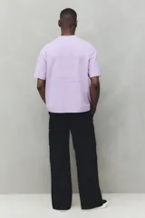 Pantalón cargo negro de corte holgado, con cintura elástica, bolsillos laterales, bolsillos tipo cargo con solapa y botón a presión en los laterales y bolsillos traseros con solapa y botón a presión.