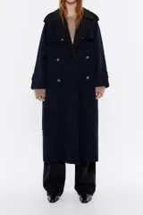 Abrigo maxilargo doble faz con mezcla de lana en color marino con interior en color marrón. Modelo con escote con maxisolapas, manga larga con puño y trabillas, y cierre frontal con doble botonadura. Canesú en el delantero y la espalda, cinturón de tejido y bolsillos con vivo.