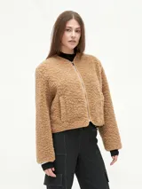 Campera marrón de tela tipo sherpa con cierre frontal y bolsillos laterales.