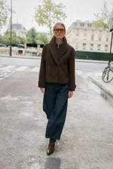 Abrigo corto de paño en color marrón chocolate, con cuello de solapa, cierre frontal cruzado con botones y mangas largas con detalle de trabilla y botón en los puños.