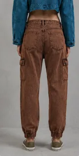 Pantalón tipo cargo de corte holgado en color marrón con efecto lavado oxidado. Presenta bolsillos laterales tipo cargo, cintura con trabillas y puños elásticos en los tobillos.