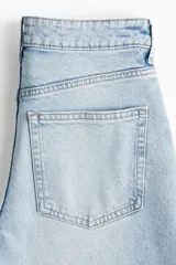 Pantalón de jean celeste de corte ancho, tiro alto y largo tobillero.